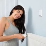 Frau am Heizungs-Thermostat